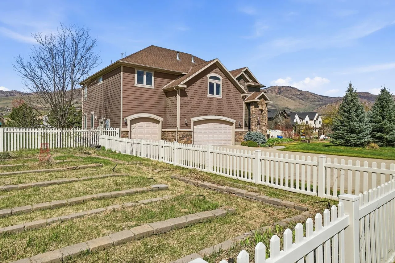 Two-story residence with a multi-car garage, brown siding, and stone accents