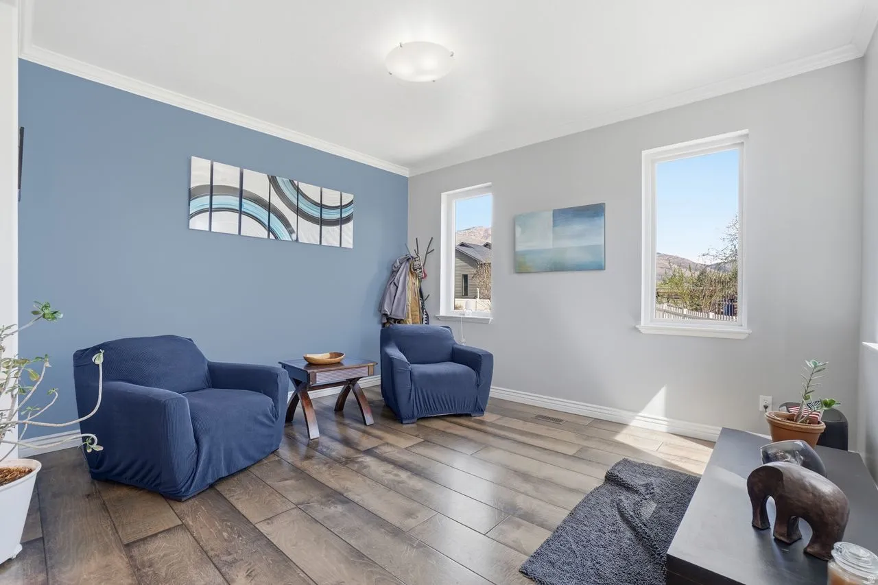 Wood-finish flooring, crown molding, and multiple windows