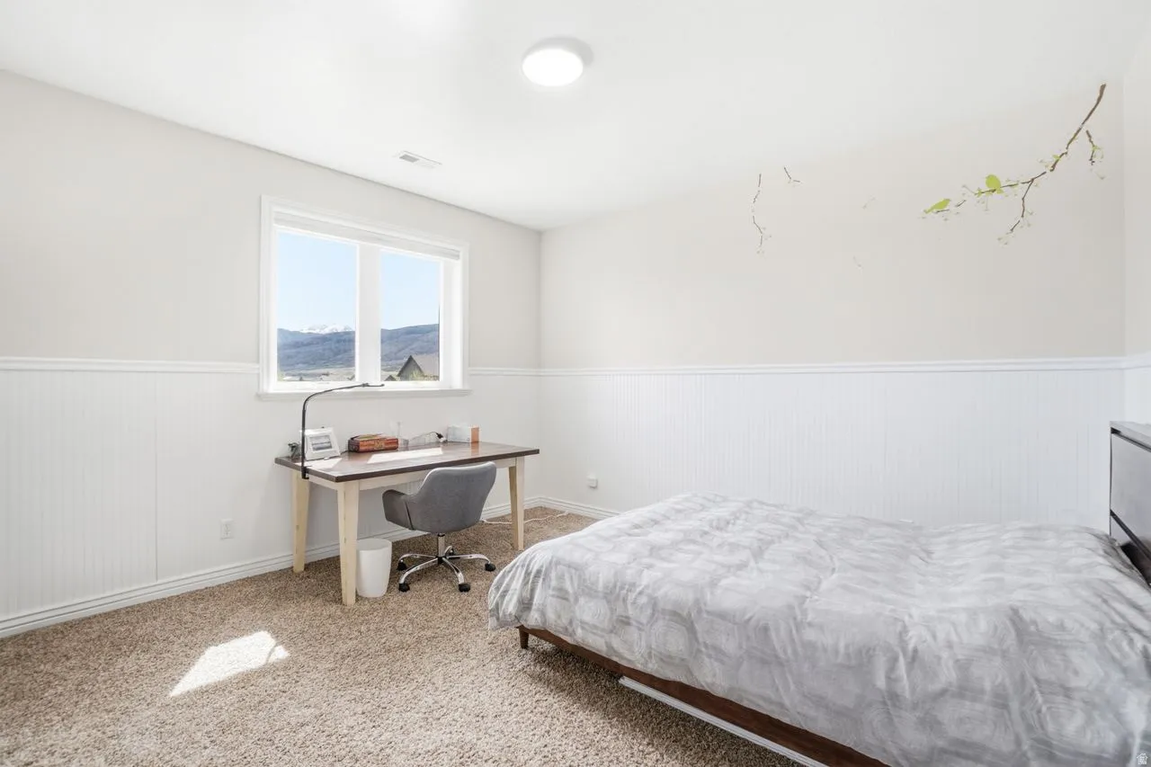 Recessed ceiling light, carpet flooring, wainscoting, and large window