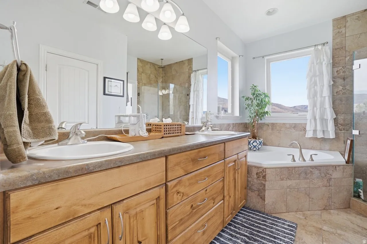Dual vanity with light wood cabinetry and integrated sinks