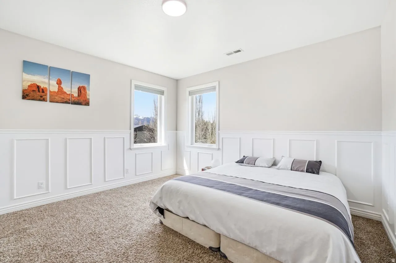 Wall paneling, neutral carpeting, recessed lighting, double windows, mountain scenery