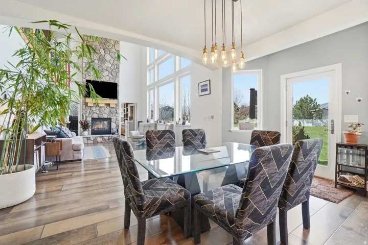 Vaulted ceilings, a full-height stone fireplace, and floor-to-ceiling windows with transom elements
