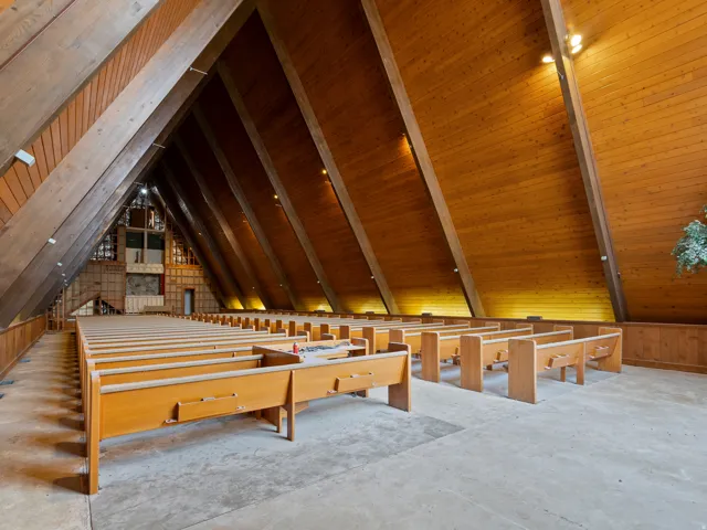 Vaulted wood-paneled ceilings with exposed beams, ample open-concept space, and built-in wood seating