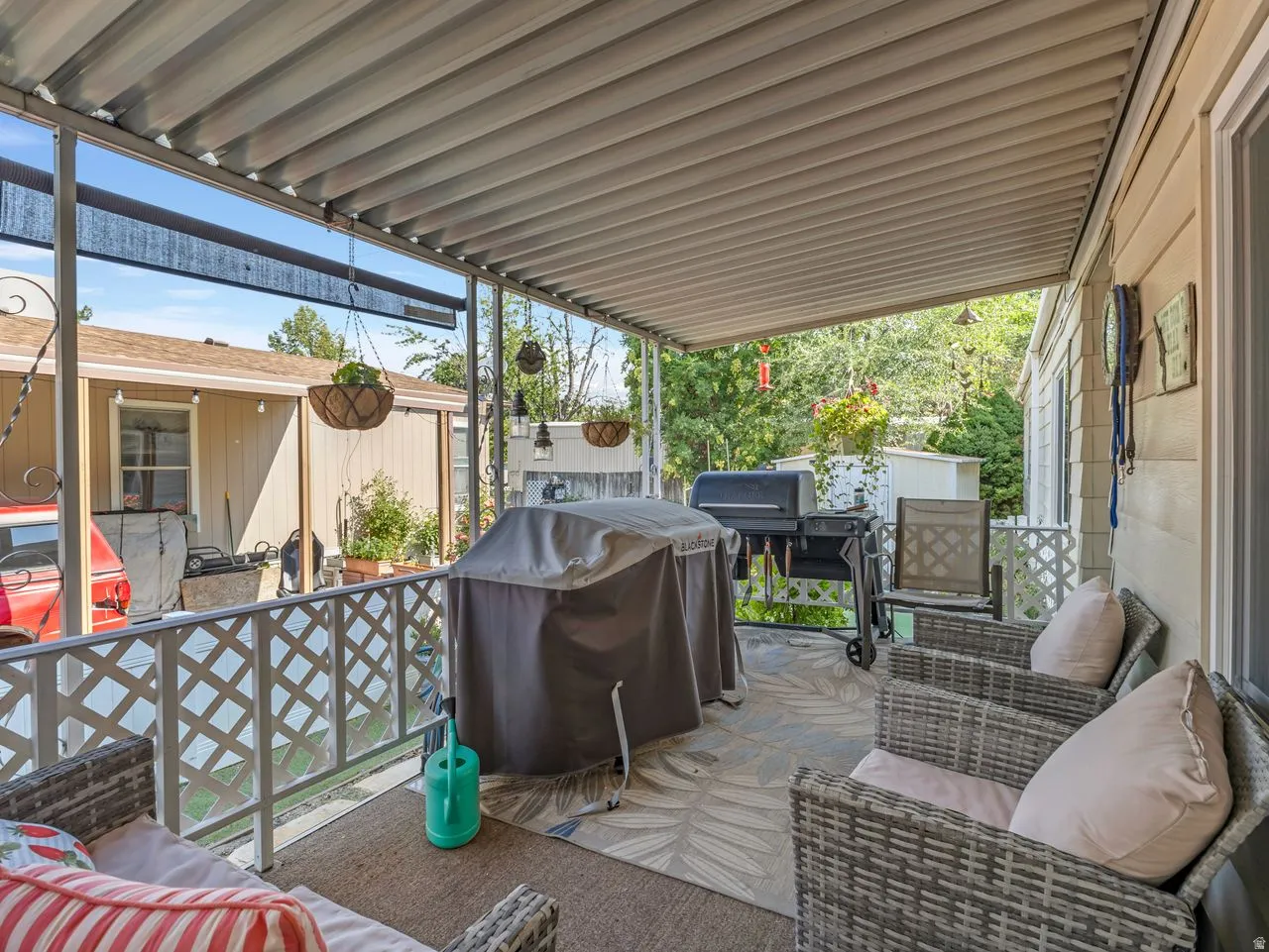 Covered patio featuring a lattice railing and a textured outdoor rug