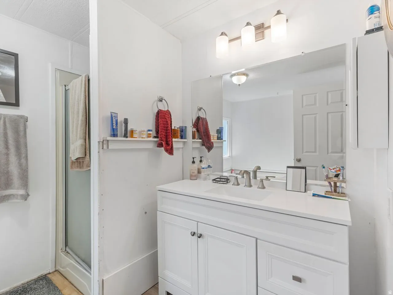 White vanity with undermount sink, brushed nickel faucet, and integrated countertop
