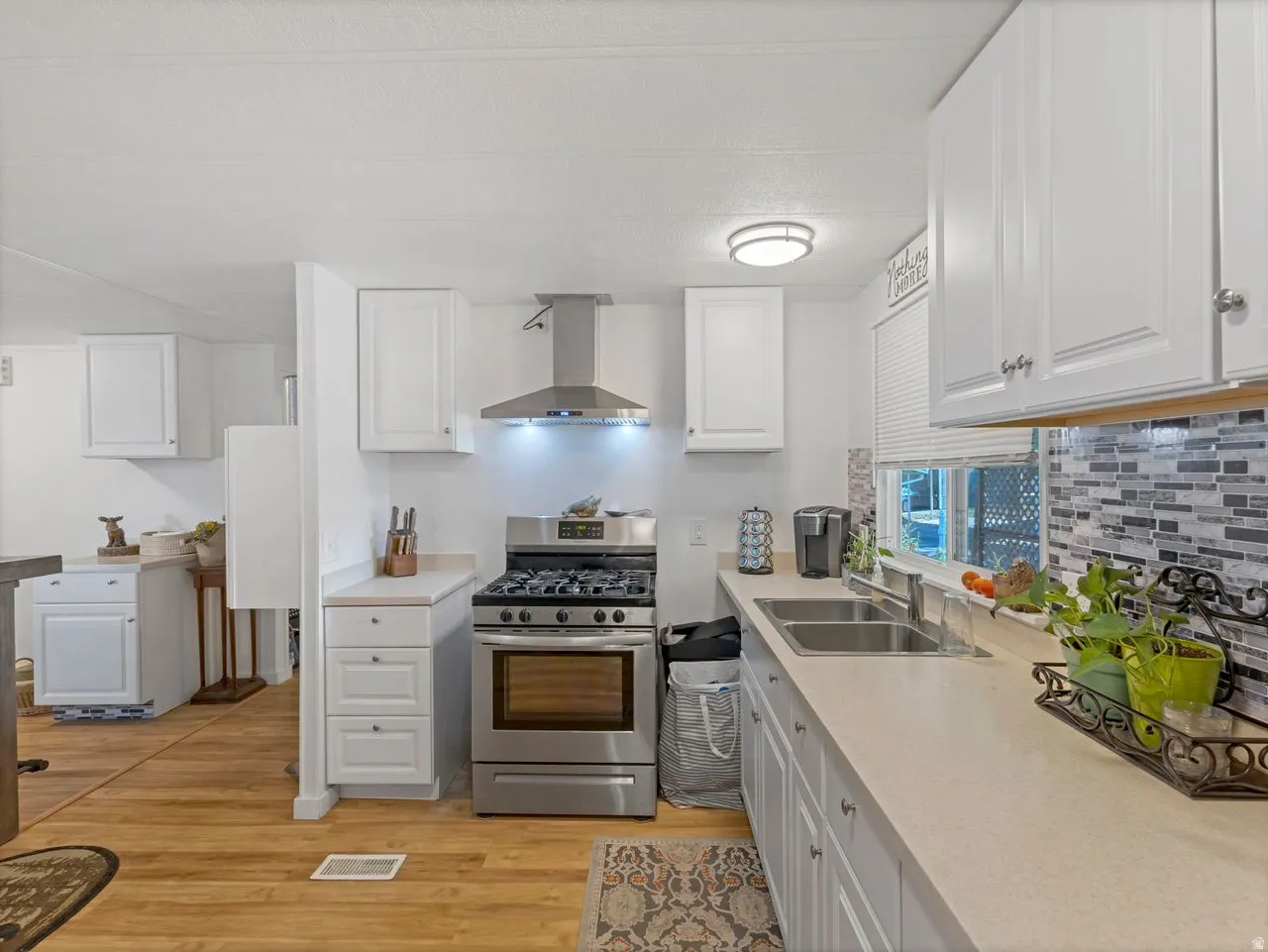 Kitchen featuring stainless steel range, hood, and double basin sink