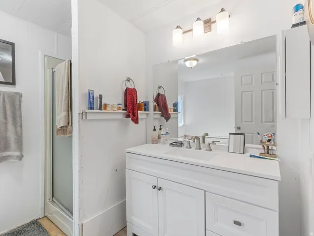 White vanity with undermount sink, brushed nickel faucet, and integrated countertop