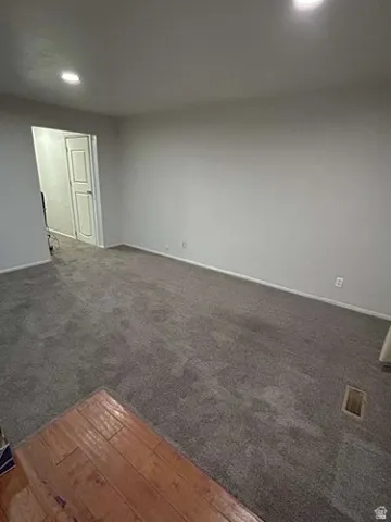 Recessed lighting, light gray wall finishes, gray carpeting, and wood-finish flooring