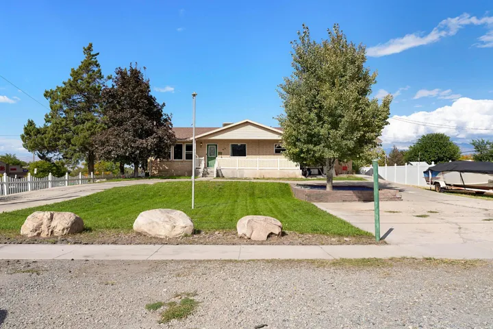 Front exterior with a concrete driveway and an expansive lawn