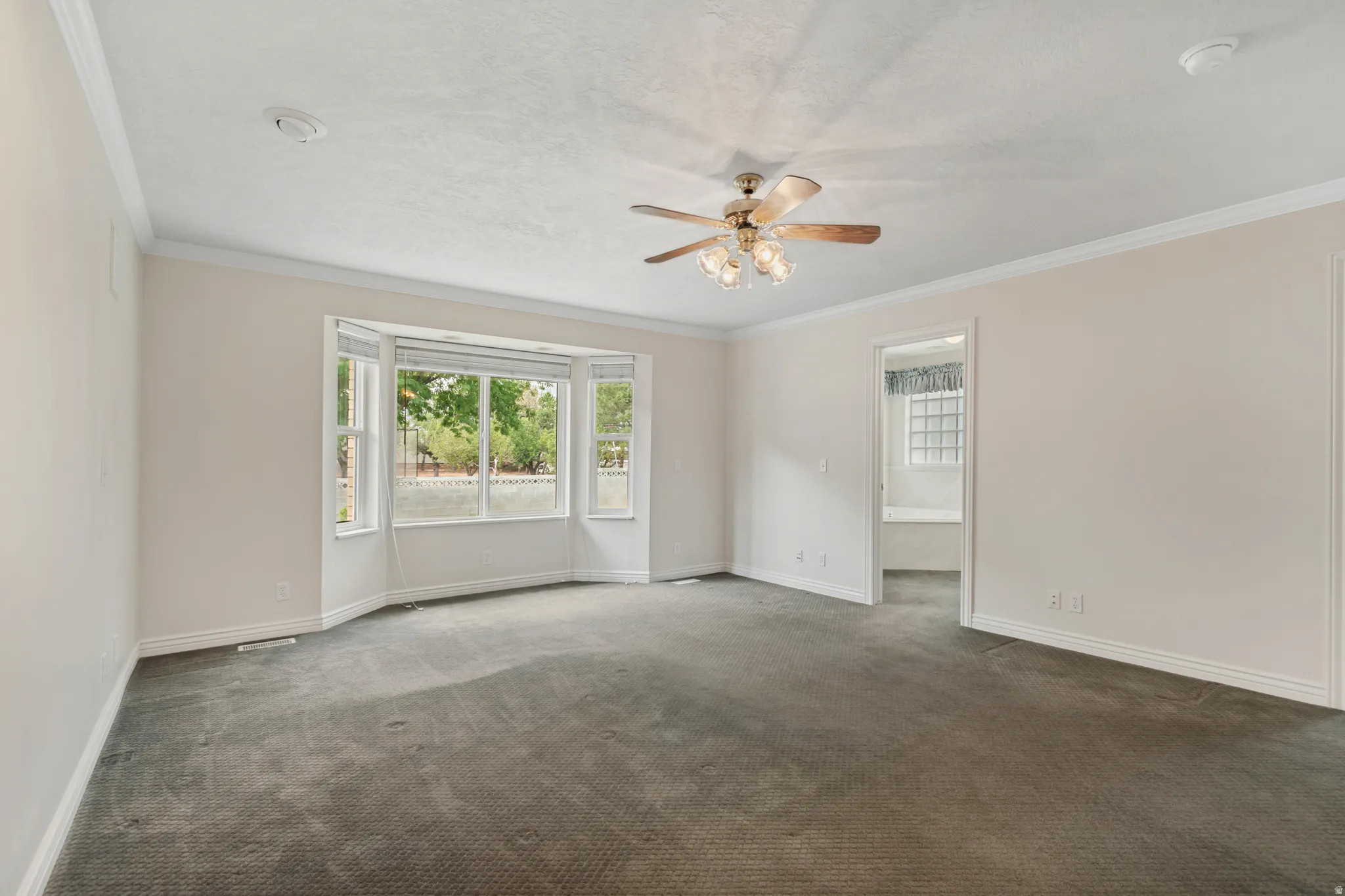 Bay window, crown molding, ceiling fan, carpet flooring, recessed lighting