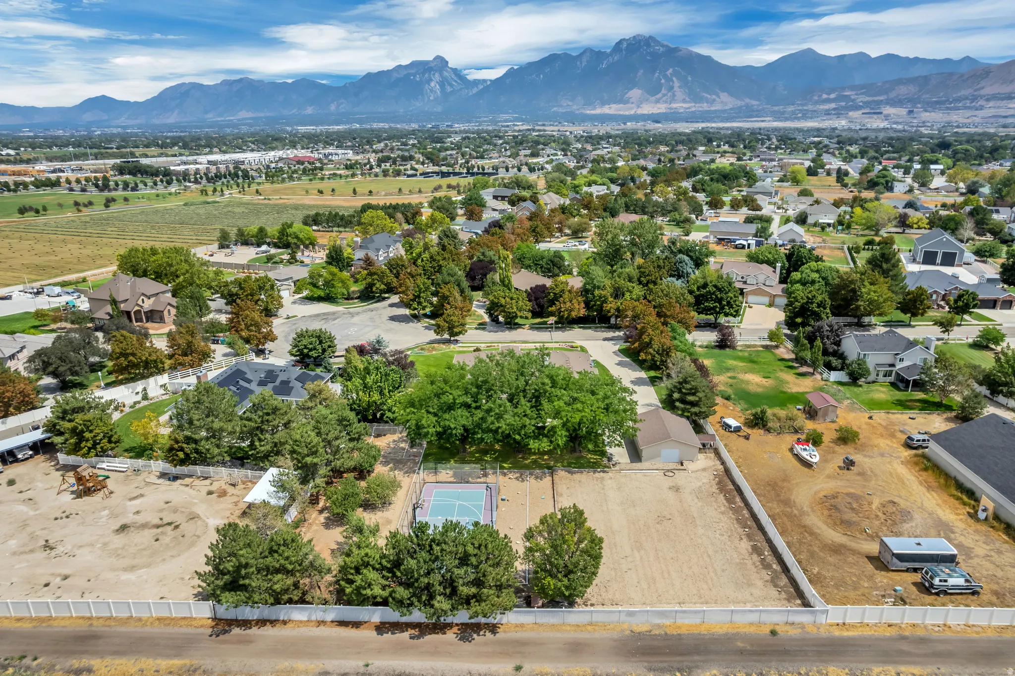 Expansive lot with mature trees, a dedicated sports court, and mountain backdrop