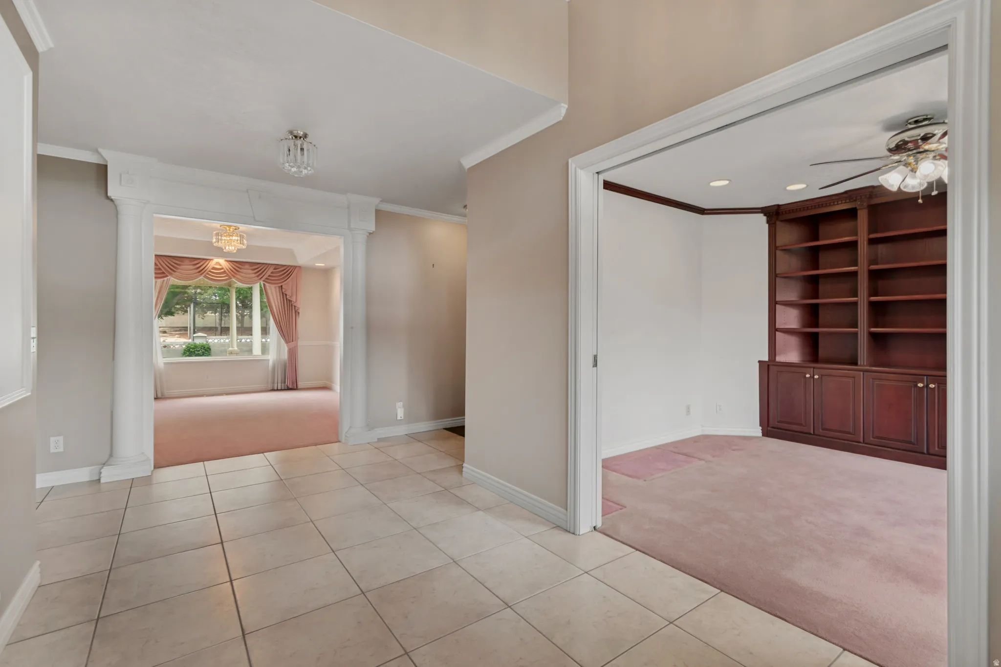 Tile flooring, built-in shelving, ornate archway, decorative ceiling light fixture, and recessed lighting