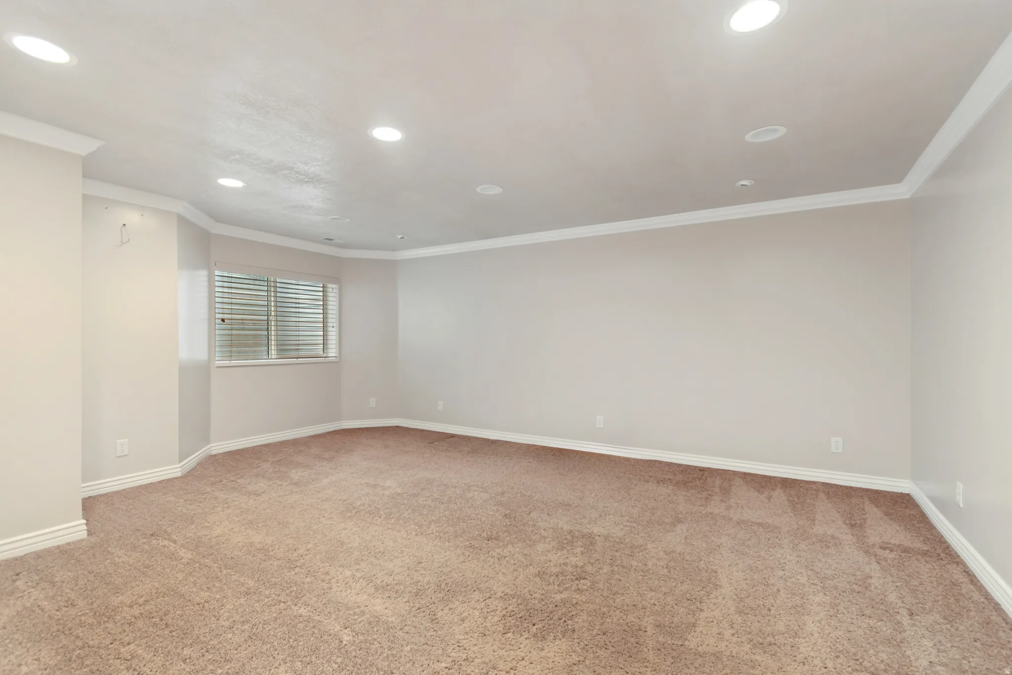 Recessed lighting, crown molding, neutral wall color, window with blinds, and carpeted flooring