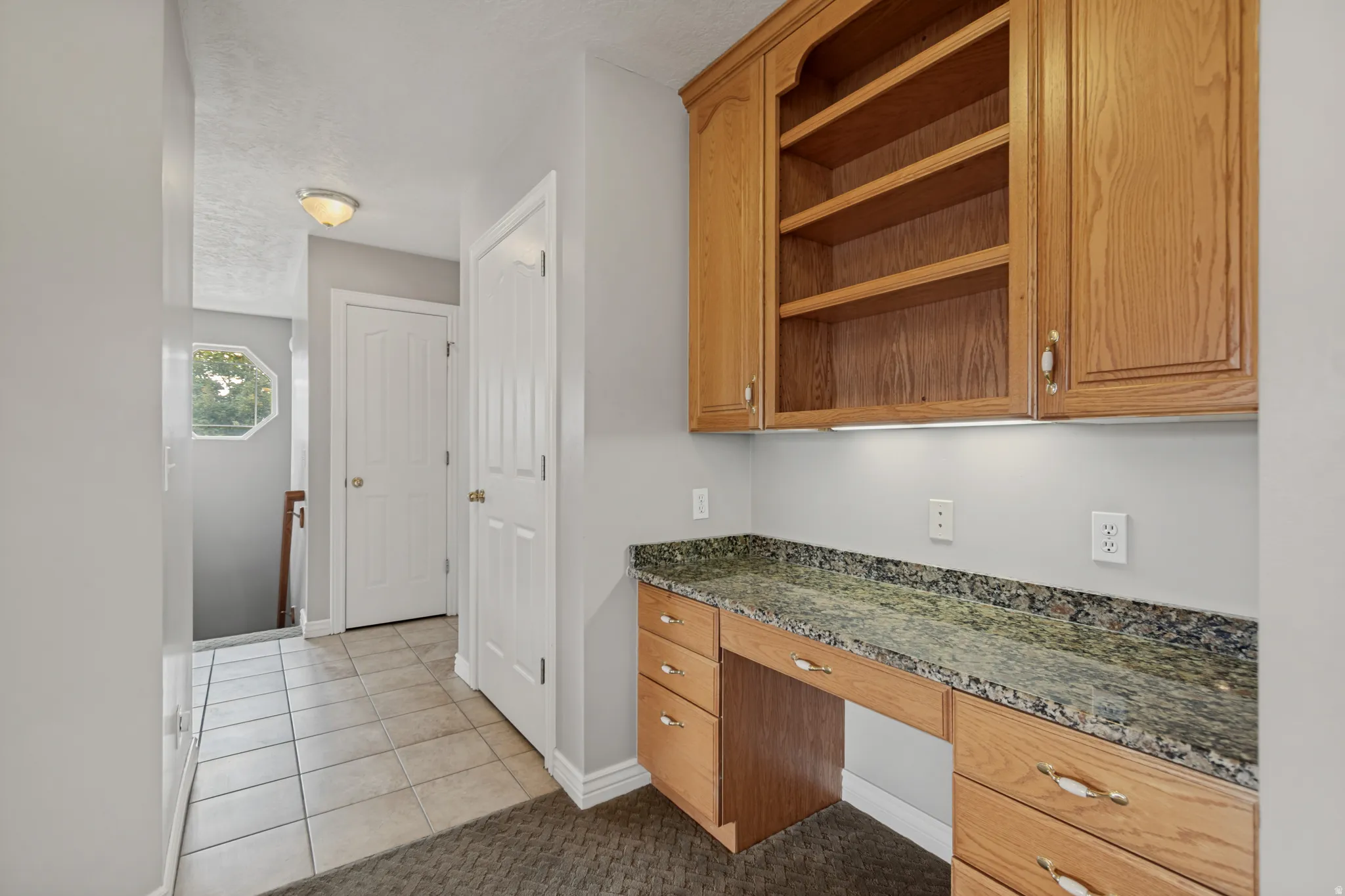 Built-in wood-finish cabinetry featuring open shelving and under-cabinet lighting