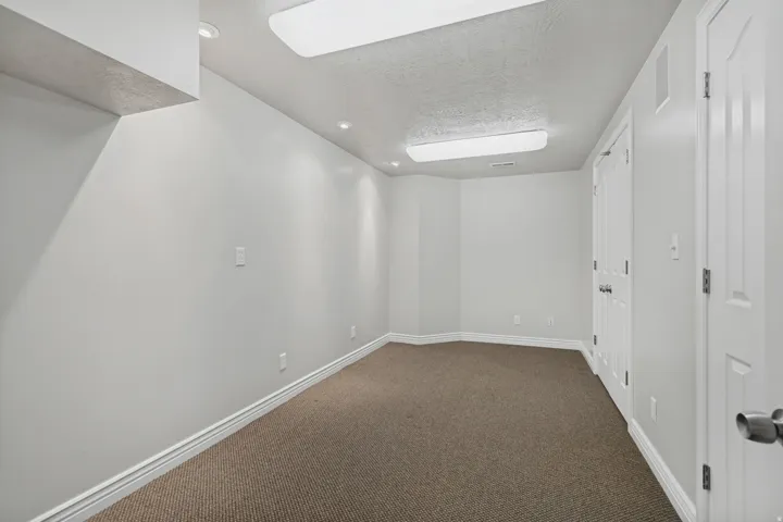 Neutral wall paint, recessed lighting, double closet doors, white panel doors, and brown carpeting