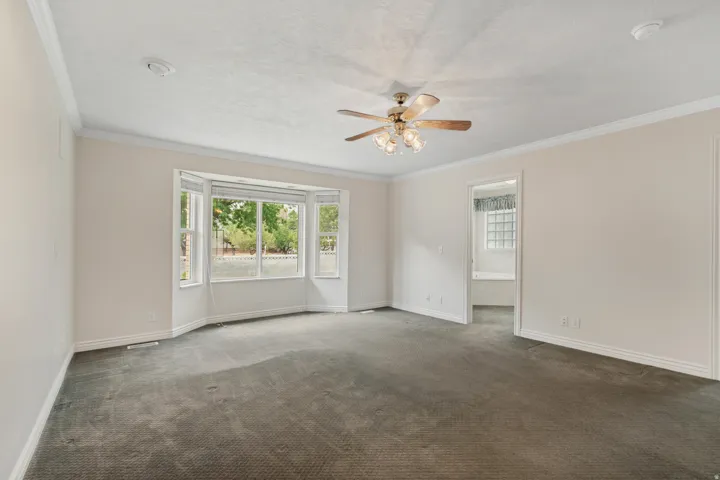 Bay window, crown molding, ceiling fan, carpet flooring, recessed lighting