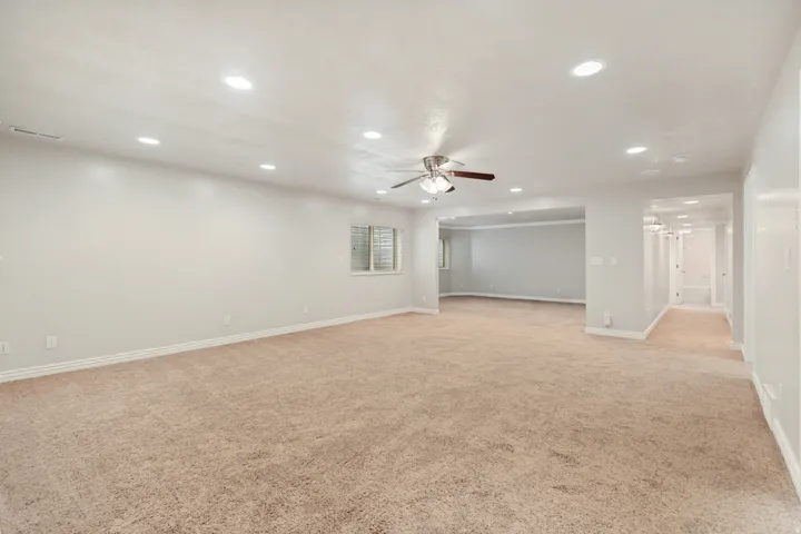 Recessed lighting, ceiling fan with light kit, neutral carpet, window with blinds, and light-toned wall paint