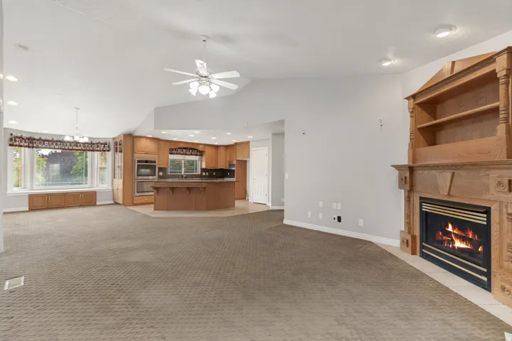 Vaulted ceilings, built-in shelving, fireplace, kitchen island, and recessed lighting