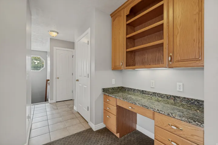 Built-in wood-finish cabinetry featuring open shelving and under-cabinet lighting