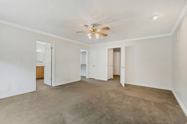 White walls with crown molding, ceiling fan with integrated lighting, recessed lighting, and carpeted flooring