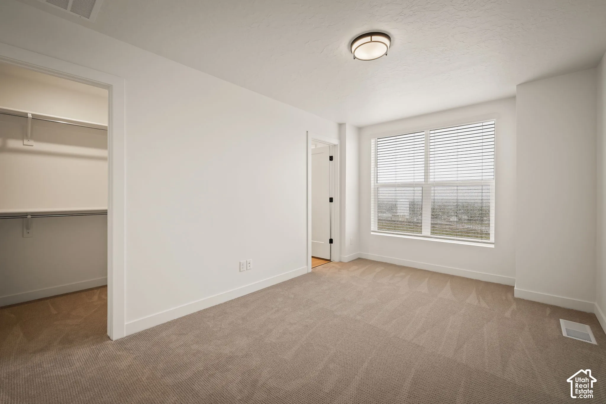 Neutral-toned carpeted flooring complements the crisp white walls