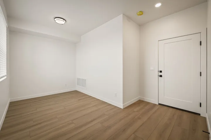 Warm wood-finish flooring complements the neutral wall tones