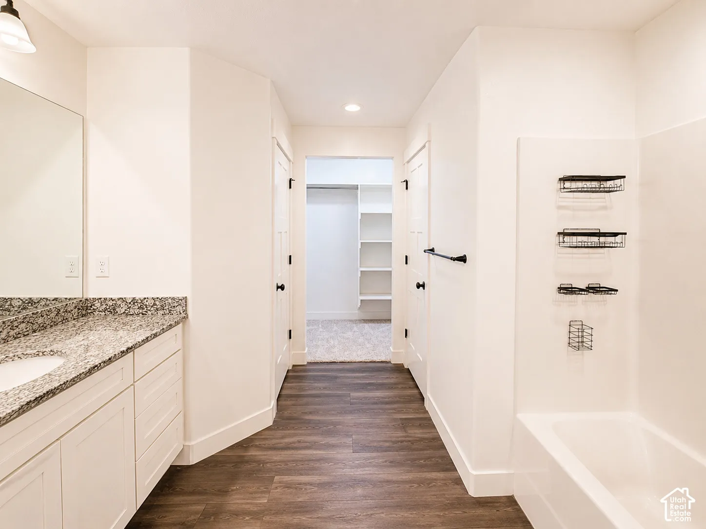 White vanity with a granite-style countertop and undermount sink