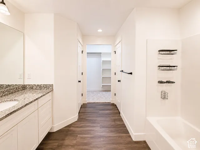 White vanity with a granite-style countertop and undermount sink