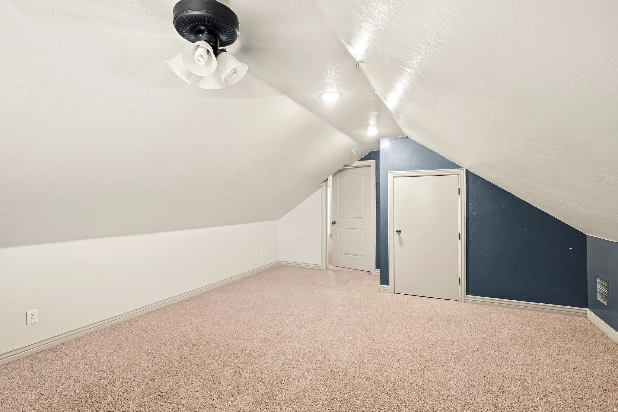 Sloped ceiling room featuring recessed lighting, a ceiling fan, and carpeted flooring