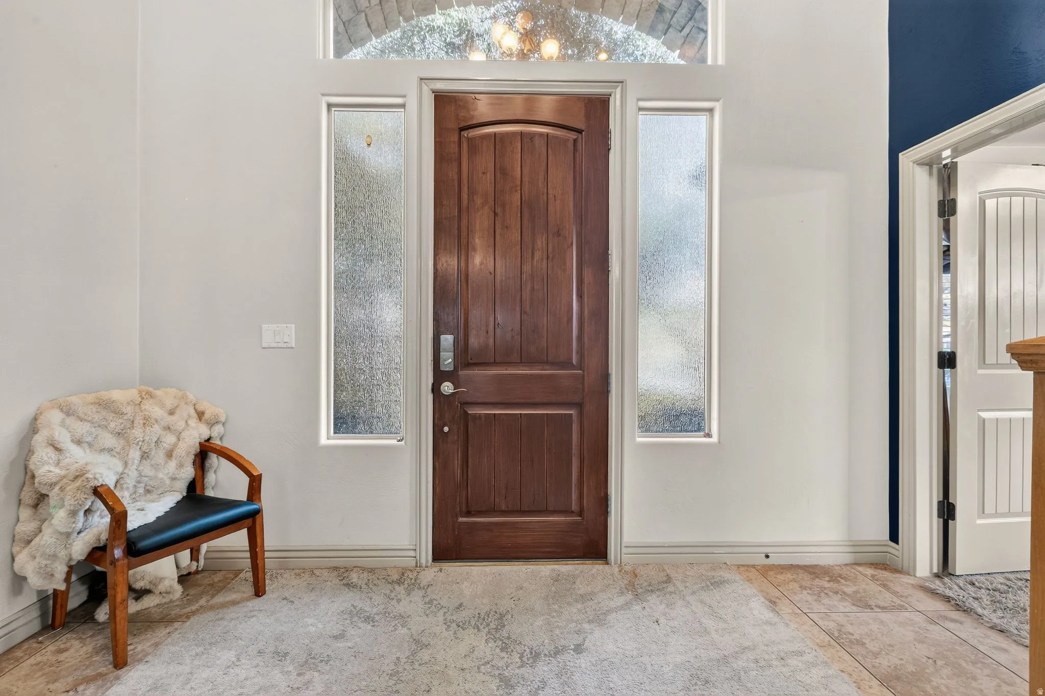 Wood-paneled entry door with sidelight windows