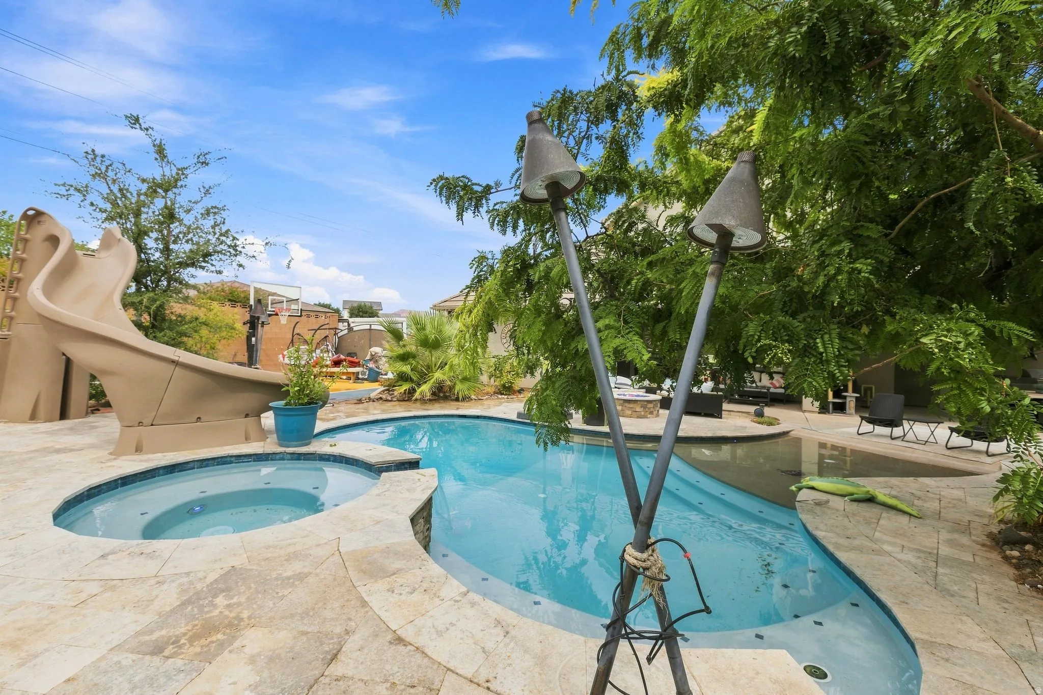 Outdoor pool with integrated spa and stone coping
