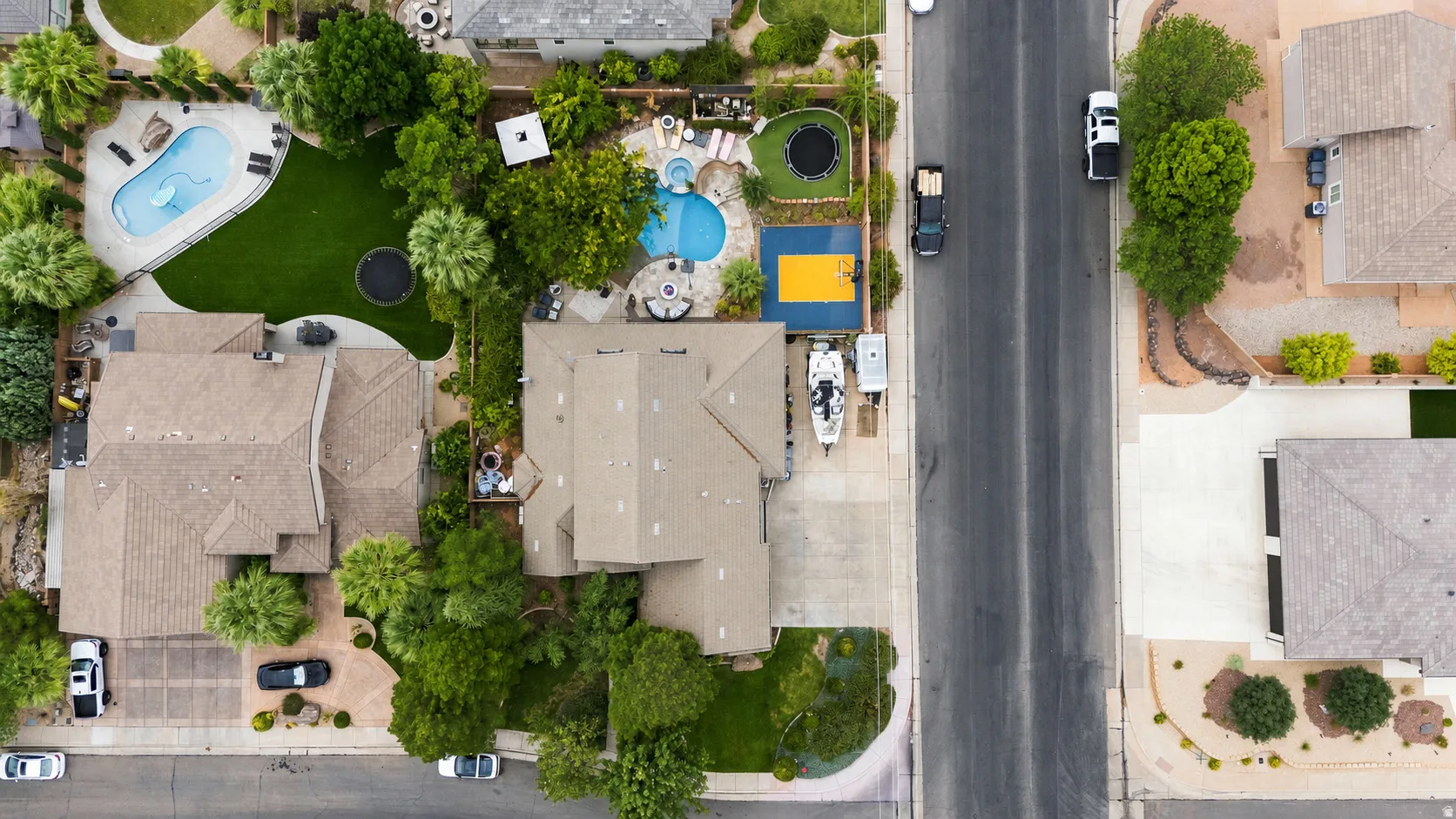 Property featuring a private swimming pool, artificial turf lawn, and mature landscaping