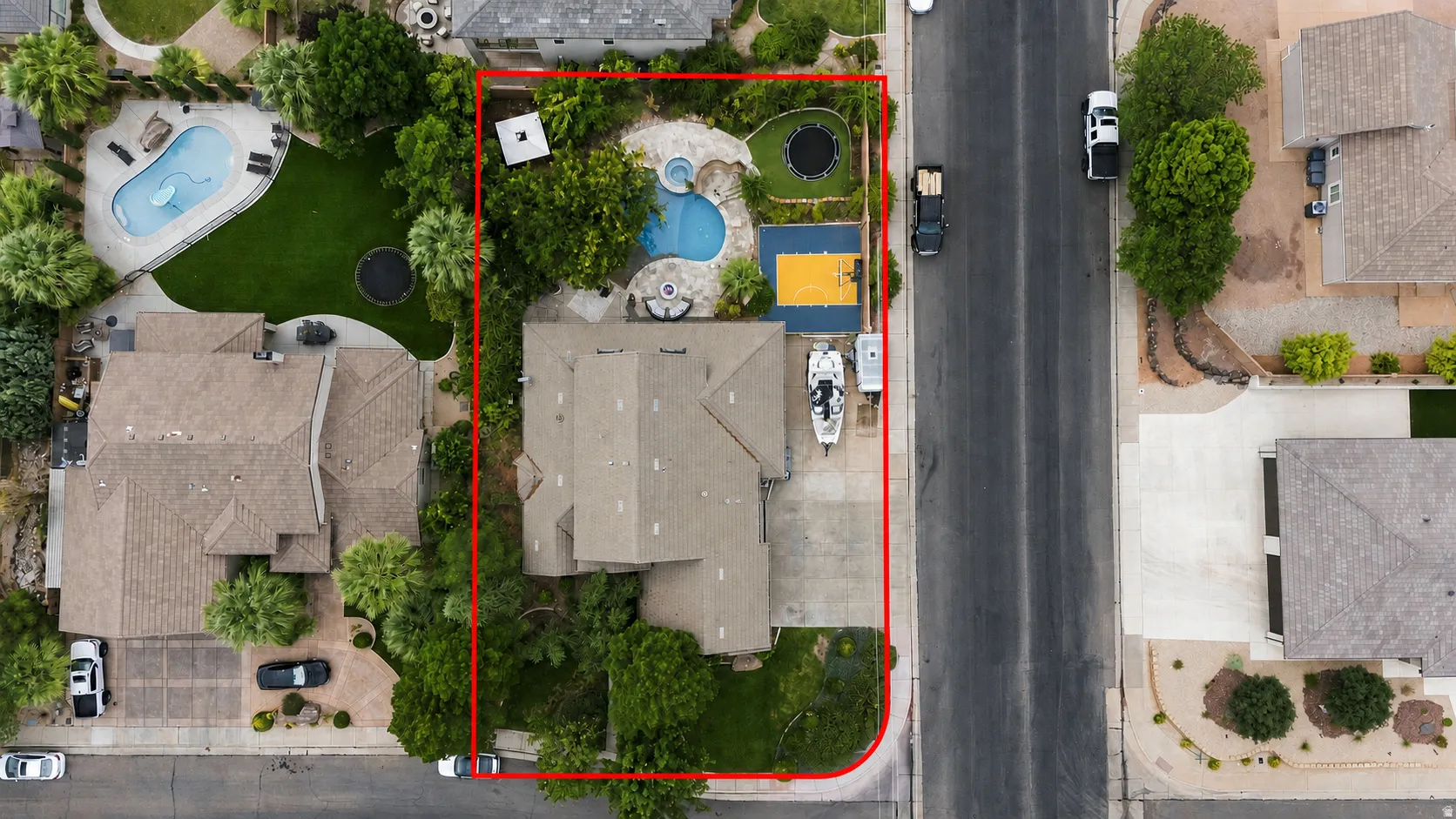 Expansive backyard featuring a blue swimming pool, a yellow sports court, and a separate grassy area