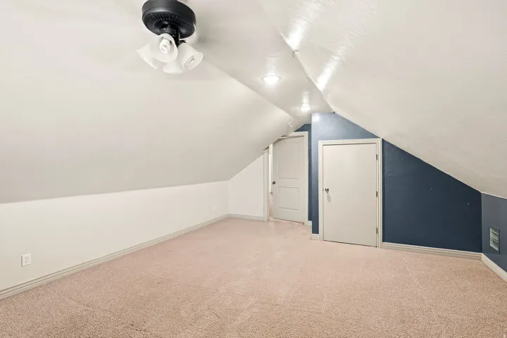 Sloped ceiling room featuring recessed lighting, a ceiling fan, and carpeted flooring