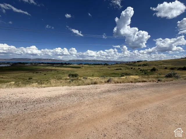 Expansive natural landscape featuring rolling hills and distant water