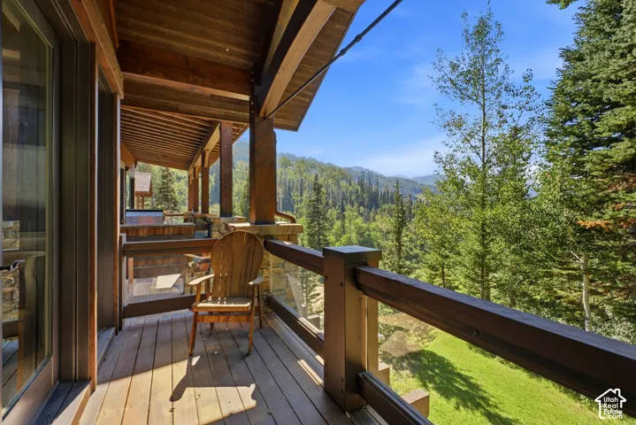 Expansive deck with wood flooring and a wood-beamed ceiling