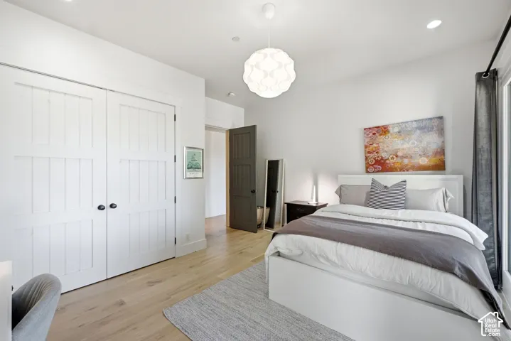 Wood-finish flooring with white walls and a contemporary pendant light fixture