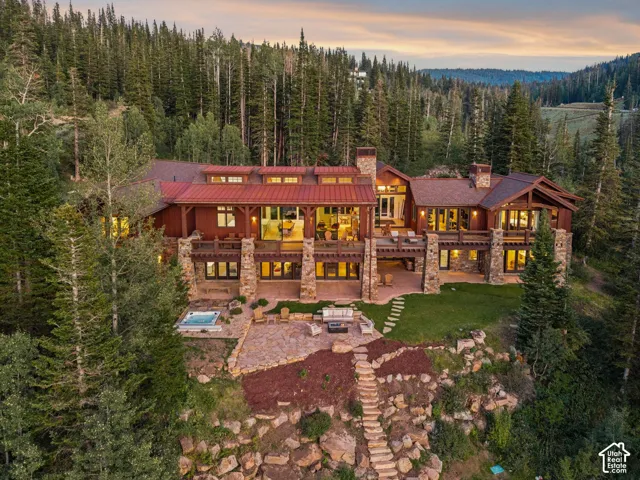Multi-level exterior featuring wood siding, stone accents, and a red metal roof