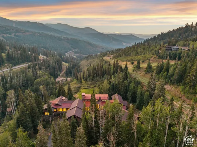 Mountain property with a multi-gabled roof, surrounded by mature trees and natural landscaping