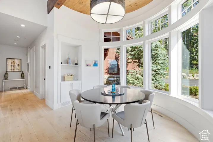 Curved window wall with multiple panels, wood-finish flooring, recessed lighting, and a built-in display niche