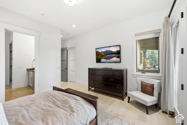 Light wood-finish flooring, recessed lighting, and a window with exterior visibility