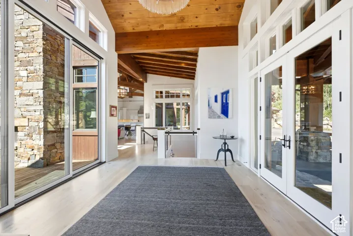Hardwood flooring, exposed wood beams, vaulted ceilings, and extensive glazing