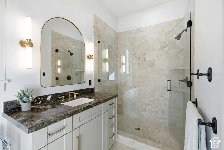 Vanity with a dark patterned countertop and undermount sink