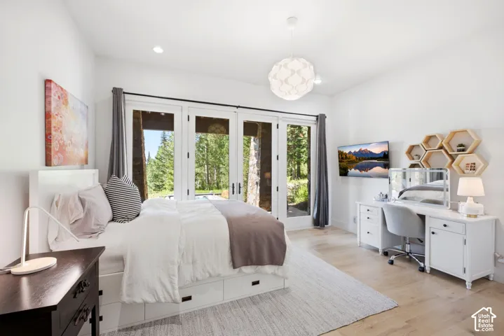 French doors providing exterior access, recessed lighting, a modern pendant light fixture, and wood-finish flooring