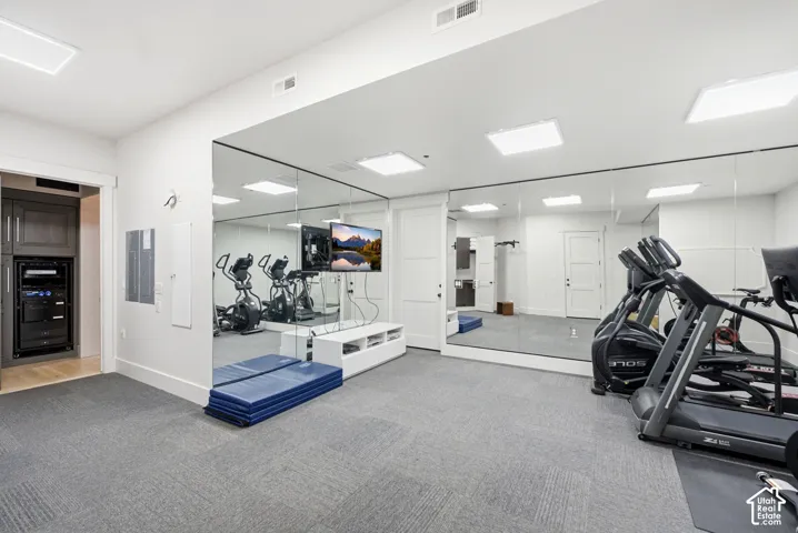 Wall-to-wall mirrors with a flat-screen television and recessed lighting