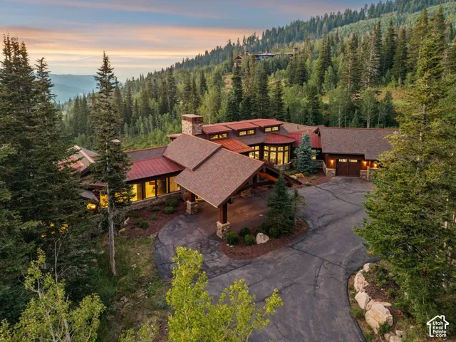 Mountain chalet-style residence with a red-toned roof, stone accents, and a covered entryway