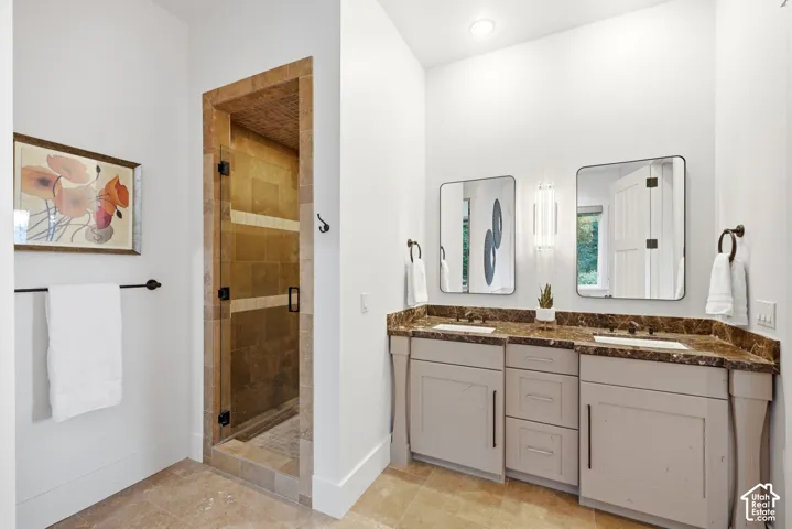 Dual vanity with integrated sinks, rich brown countertops, and coordinating light gray cabinetry