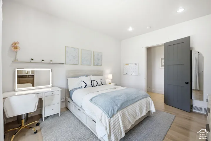Light wood-finish flooring, recessed lighting, and a neutral color palette