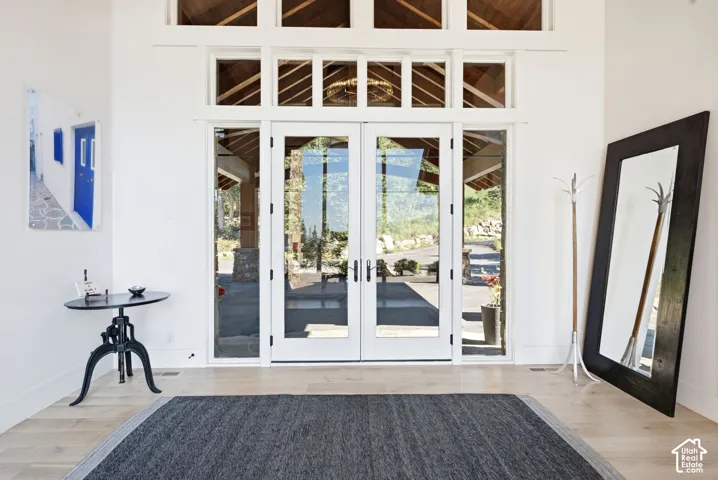 White French doors with transom windows, wood-finish flooring, and white walls