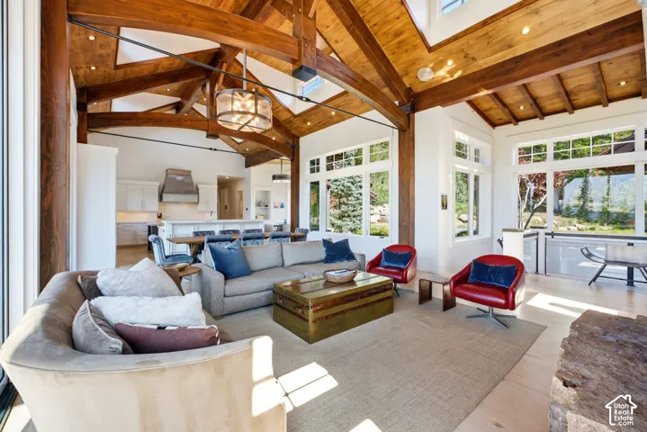 Vaulted wood-beamed ceilings, light wood-finish flooring, abundant natural light, recessed lighting, and an open-concept layout